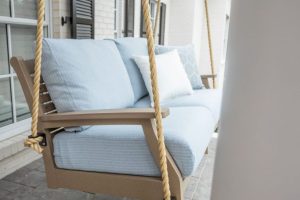Classic Terrace loveseat swing in weatherwood. Cushions in Nude Beach Skt. Pillows in Canvas natural and Schooner sky